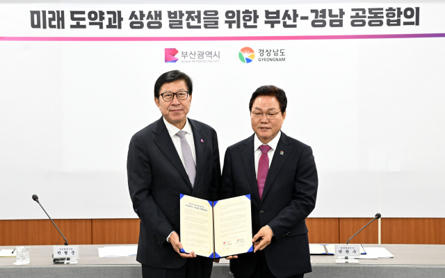 박완수 경남지사와 박형준 부산광역시장이 17일 부산시청에서 미래 도약과 상생 발전을 위한 경남-부산 공동합의문을 들고 기념촬영을 하고 있다./성승건 기자/