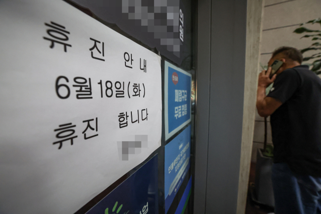 서울대병원에 이어 전국 병의원이 집단 휴진에 돌입한 18일 부산의 한 동네의원에 휴진 안내문이 붙어 있다. 김종진 기자 kjj1761@