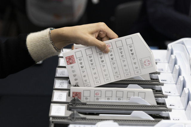 지난 10일 경기도 과천시 중앙선거관리위원회에서 열린 제21대 대통령 선거 투·개표 절차 시연회에서 투표지 분리기를 통과한 투표지를 꺼내고 있다. 연합뉴스