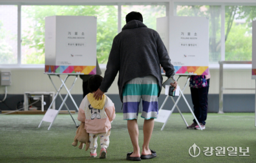 제21대 대통령선거 사전투표 첫날인 29일 춘천시 신사우동 북부노인복지관 게이트볼장에 마련된 사전투표소를 찾은 한 시민이 어린 자녀와 함께 투표에 참여하고 있다. 박승선기자