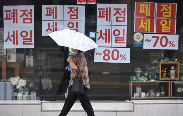 8일 창원시 성산구 상남상업지구에서 한 시민이 폐점 세일 안내문이 붙어 있는 상가 앞을 지나가고 있다./김승권 기자/