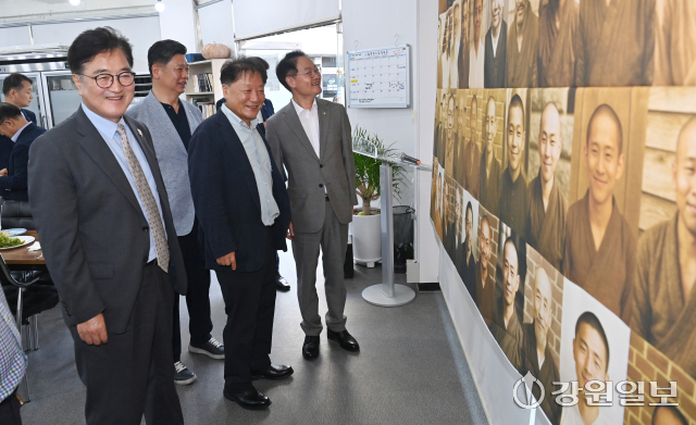 19일 영화 '독립군:끝나지 않은 전쟁' 상영행사를 위해 춘천을 찾은 우원식 국회의장이 거두리 '명랑싸롱'에서 열린 만찬에서 허영 국회의원, 최윤 강원민주재단이사장 등과 함께 강원일보가 AI를 활용해 제작한 도 출신 독립유공자의 웃는 얼굴 대형 현수막을 살펴보고 있다. 박승선기자