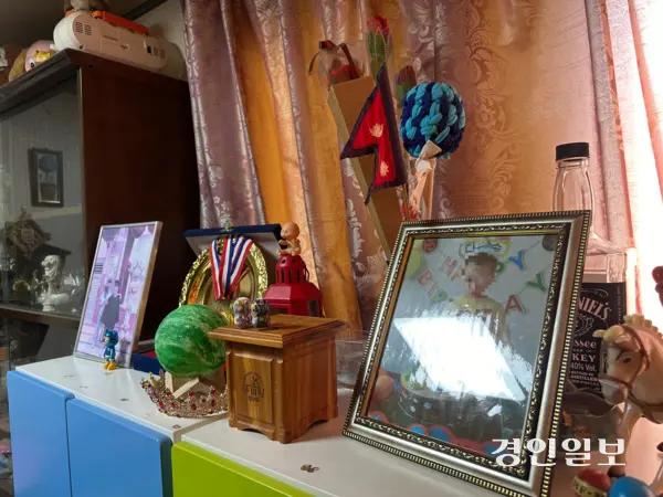 사진은 네팔 국적의 미샤(29)씨의 아들 우진씨의 어릴적 사진이 네팔 국기와 함께 진열되어 있는 모습. 중학교 1학년에 재학 중인 우진씨는 미등록 이주아동이다. 2025.8.30 /목은수기자 wood@kyeongin.com