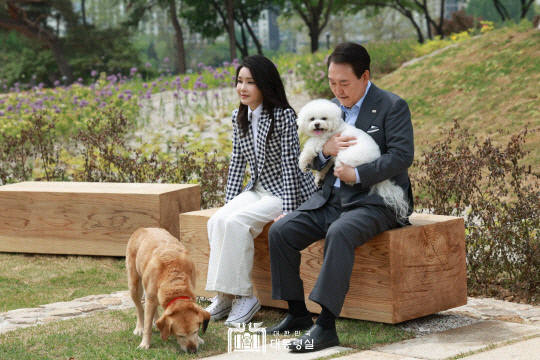지난 2023년 5월 윤석열 당시 대통령과 김건희 여사가 서울 용산 대통령실 앞 미군기지 반환부지에 조성된 용산어린이정원 내 전망언덕에서 기념식수를 마친 뒤 반려견 써니, 새롬이(왼쪽)와 휴식을 취하는 모습. 대통령실 제공