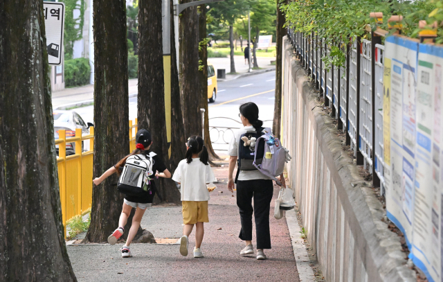 최근 전국에서 잇따른 하굣길 어린이 유인 미수 사건으로 학부모들의 불안이 커지고 있는 가운데 16일 오후 창원시 성산구 용호동 한 초등학교 앞에서 학생이 부모와 함께 하교하고 있다./전강용 기자/